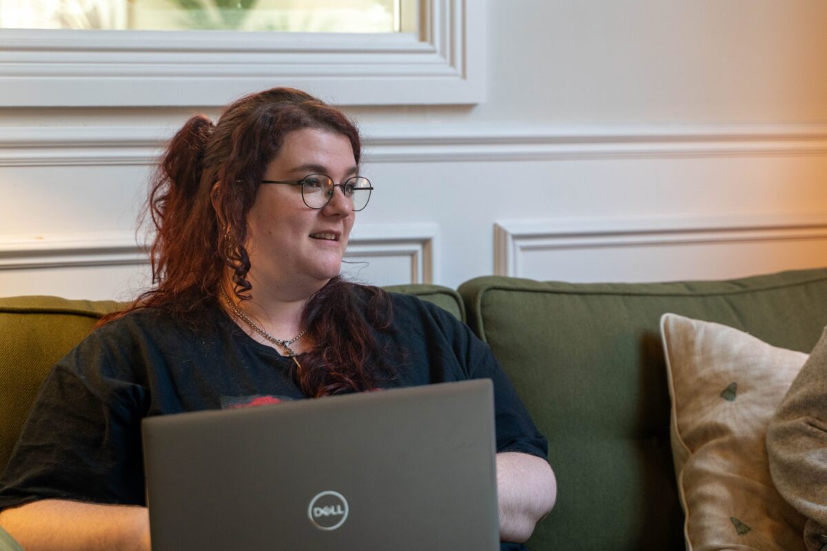 Kestra sat on a the sofa with laptop